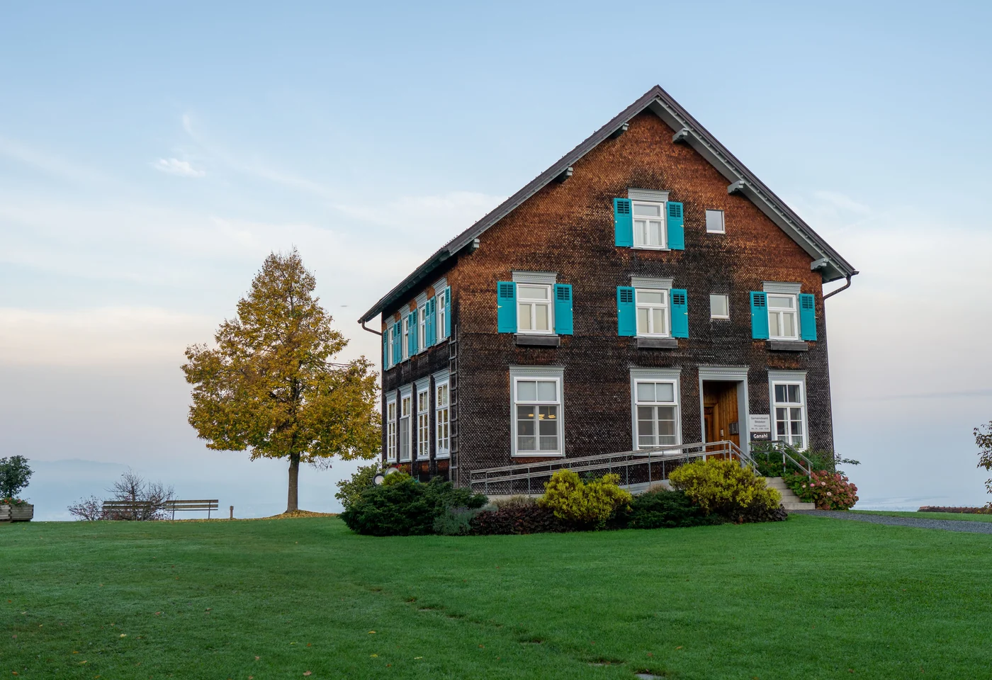 Traditionelles Haus mit Holzfassade und grünen Fensterläden